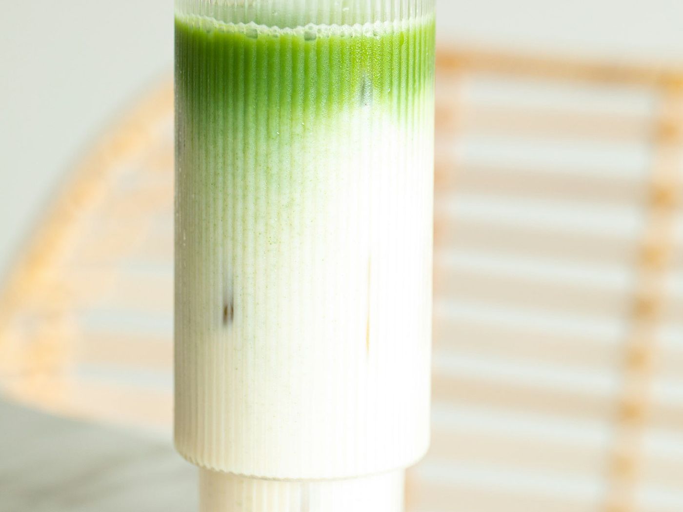 直紋玻璃杯中的綠白分層抹茶拿鐵