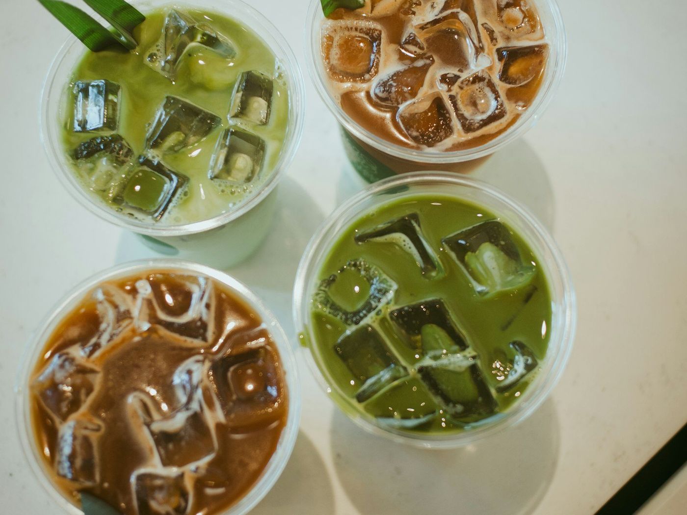 俯拍四杯加冰的抹茶與咖啡飲品